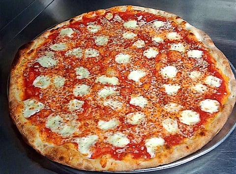 A freshly baked Margherita pizza with tomato sauce, melted mozzarella cheese, and basil on a metal pizza pan